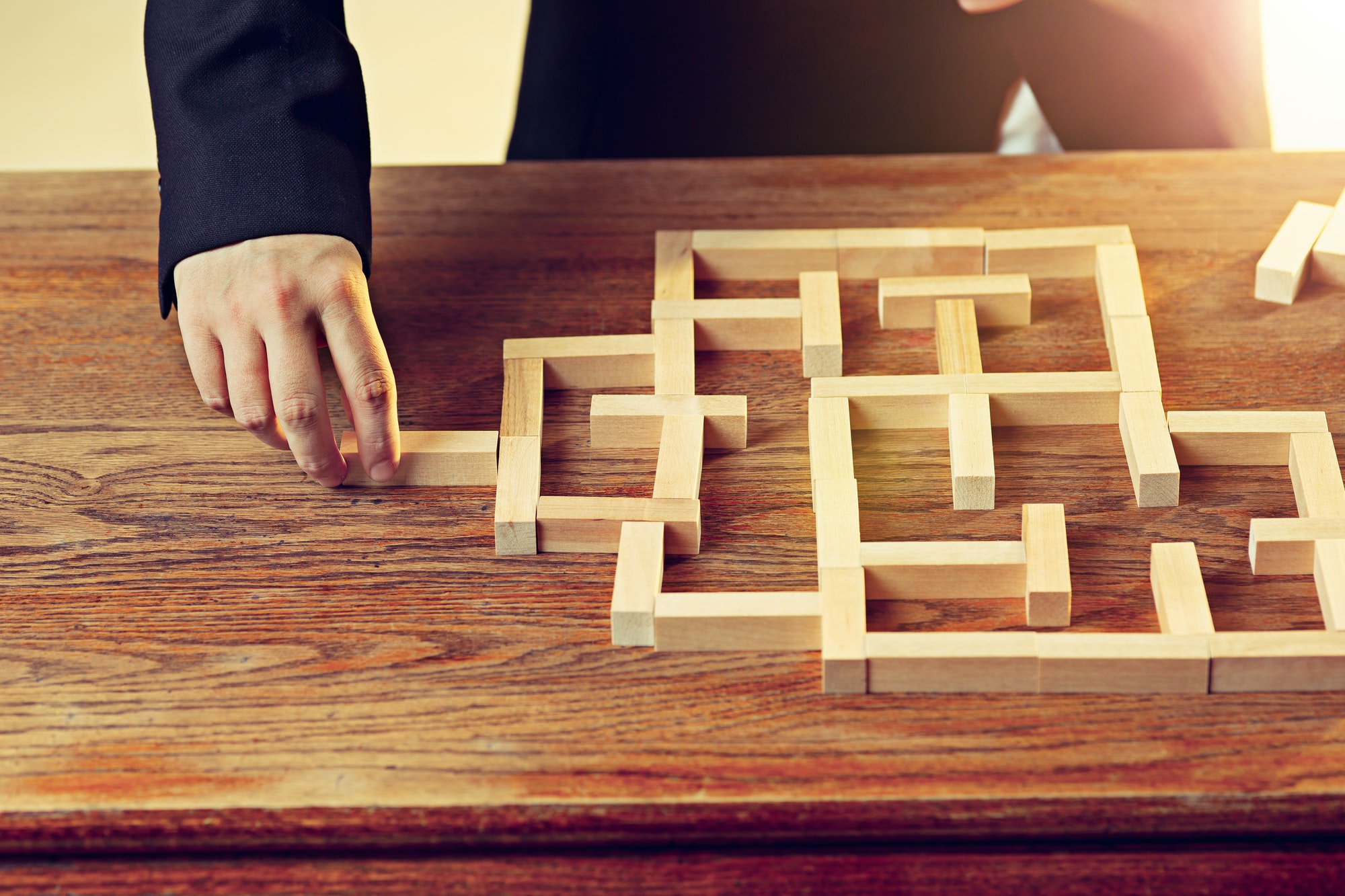 Man and wooden cubes on table. Management concept